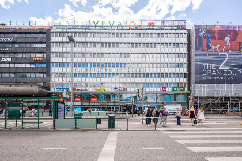 1950-luvulla valmistunut toimistotalo Kaivotalo Helsingin keskustassa, nauhaikkunat, valkoinen julkisivu ja neonkylttejä.